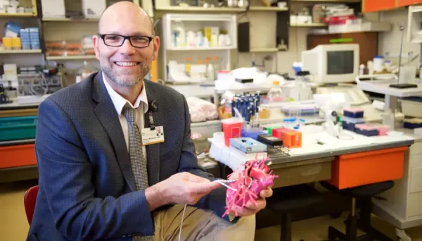 Steven Mickelsen, MD, holds a heart model