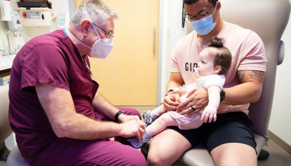 Physician examines a baby recovering from club foot 